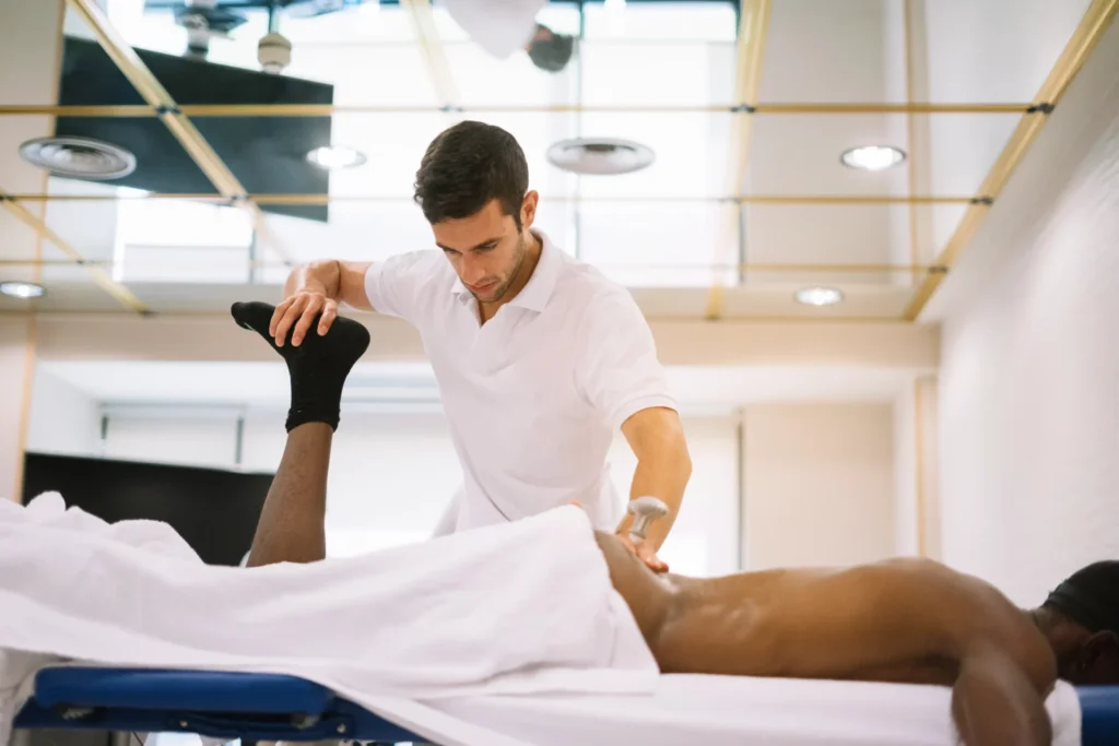 Physiotherapist performing therapeutic ultrasound on a patient’s leg during rehabilitation in a modern clinic.